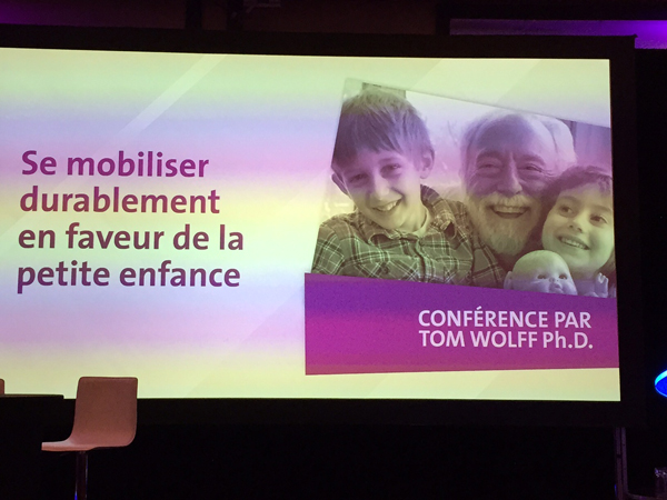 Tom Wolff Delivers | Photo of Tom and grandchildren Jonah and Liora on jumbo screen (story below) Address at Avenir D’Enfants Conference in Quebec City November 2015. 